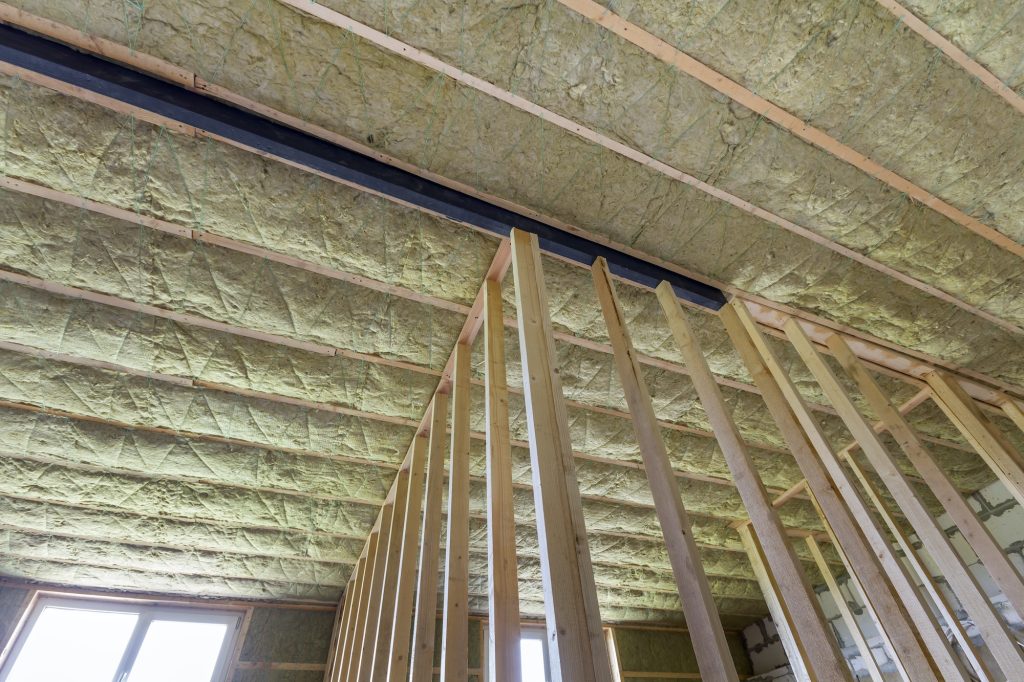 Close-up of wooden frame for future walls and ceiling insulated with rock wool and fiberglass