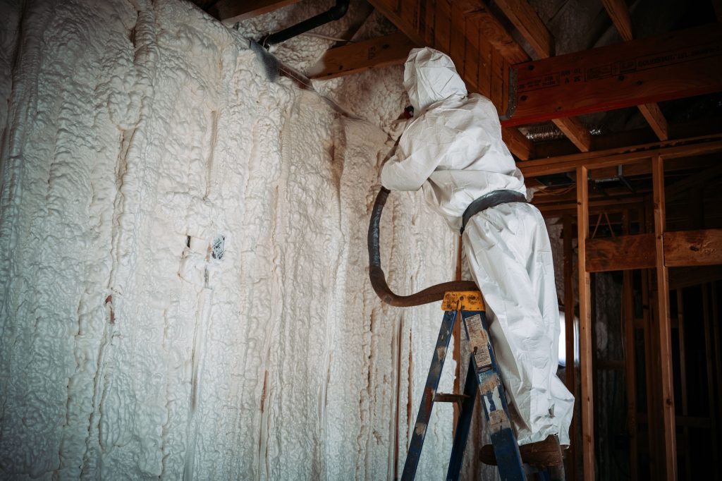 Worker doing spray foam insulation on the walls